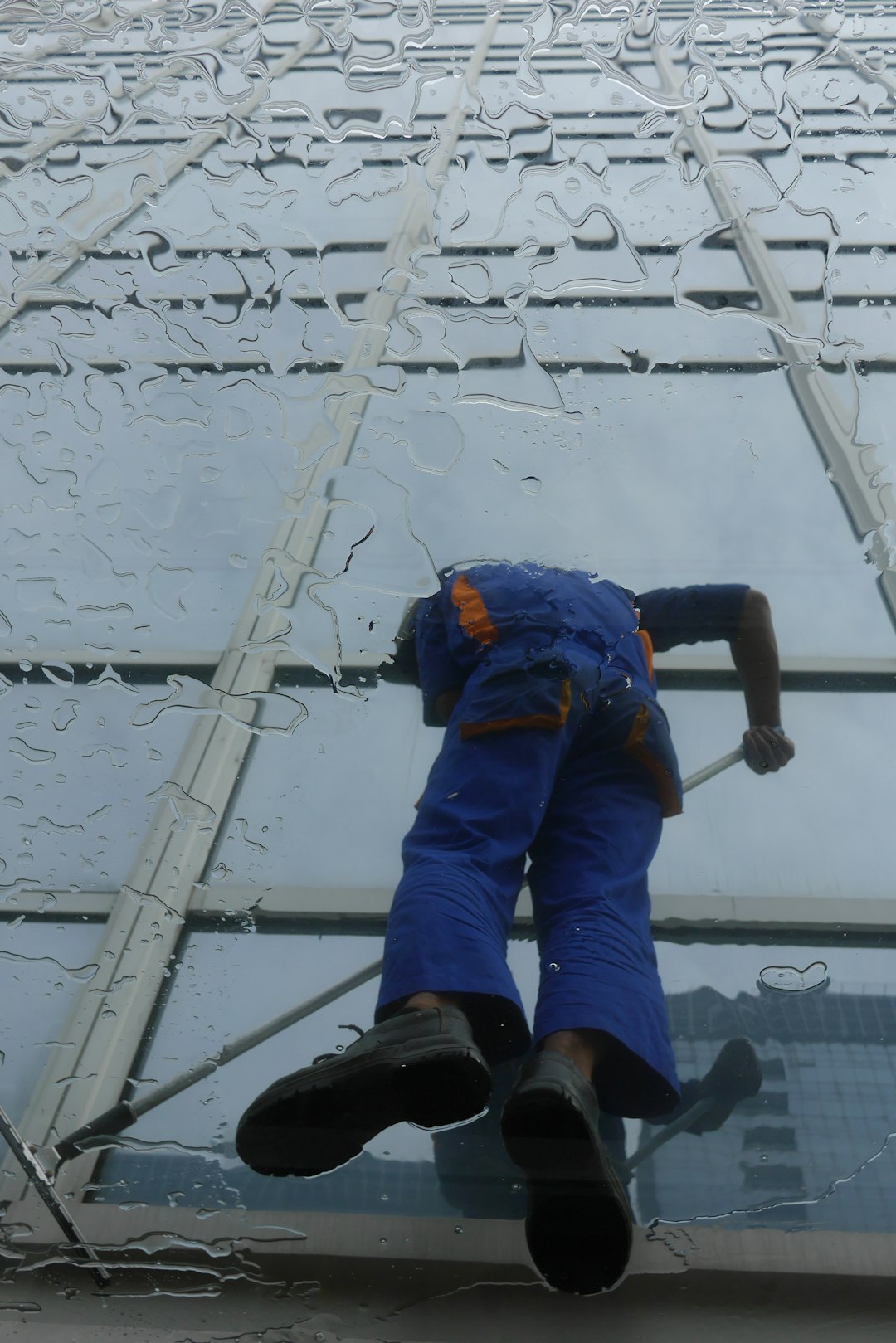 services-04 window-cleaner-working-on-a-glass-building-exterior-s6lojzu69s4