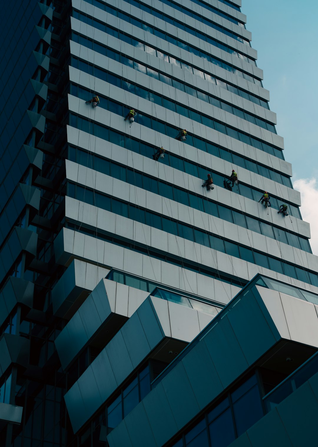 window-cleaners-work-on-a-modern-skyscraper-facade-fhdd4w2v06e
